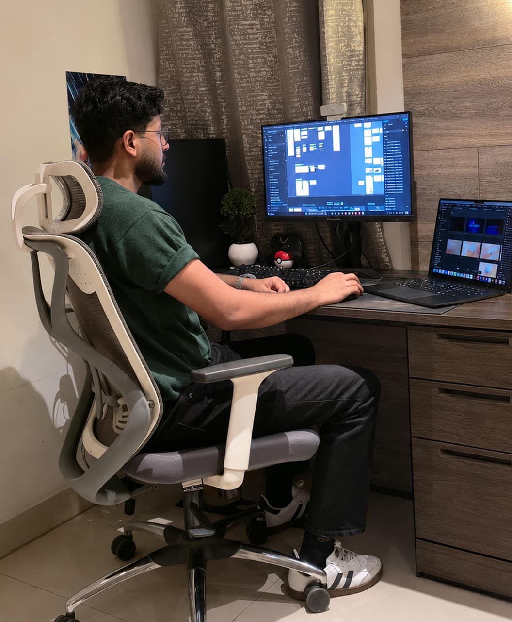 Harsh working at his desk setup with a monitor and laptop