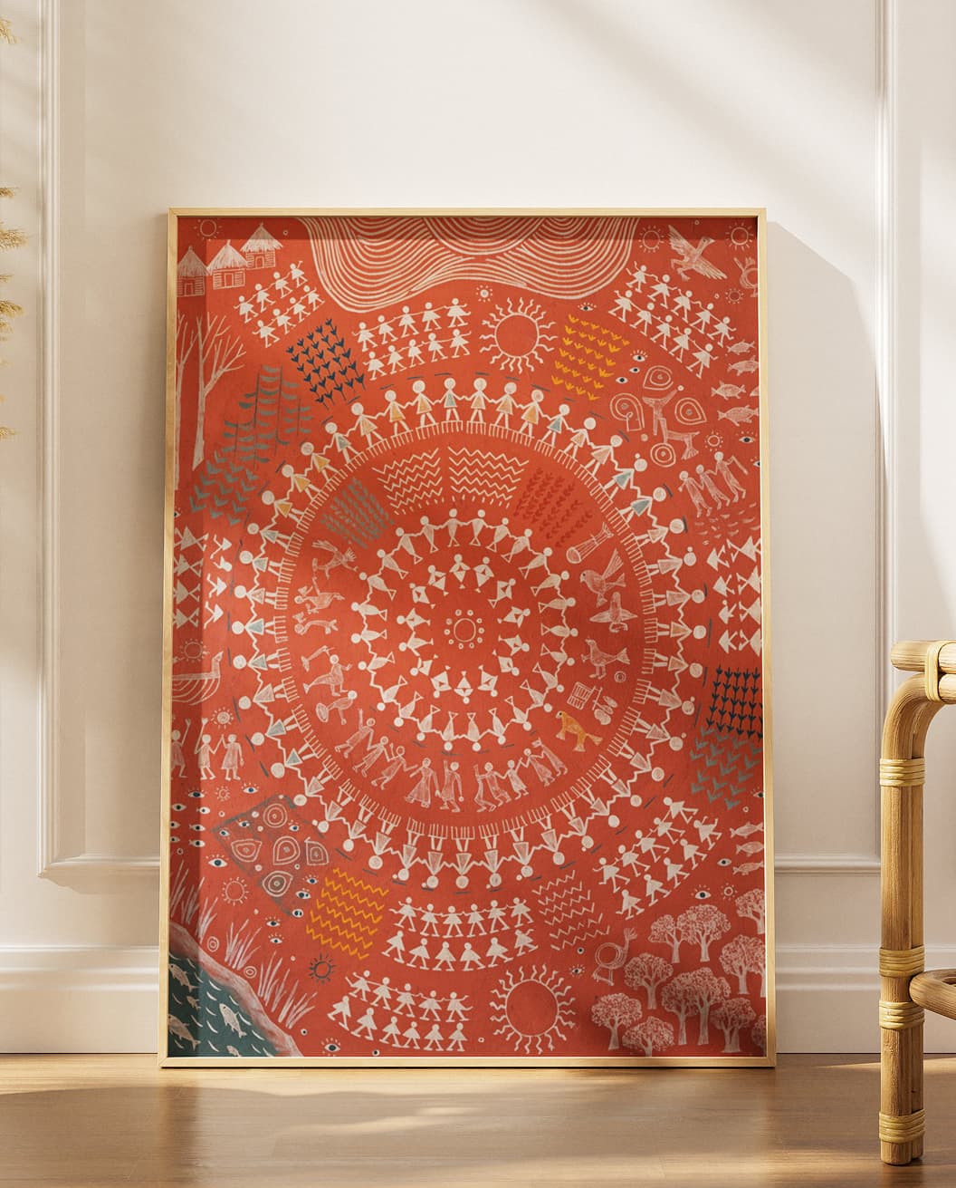 Framed Warli-style circular artwork print leaning against a wall